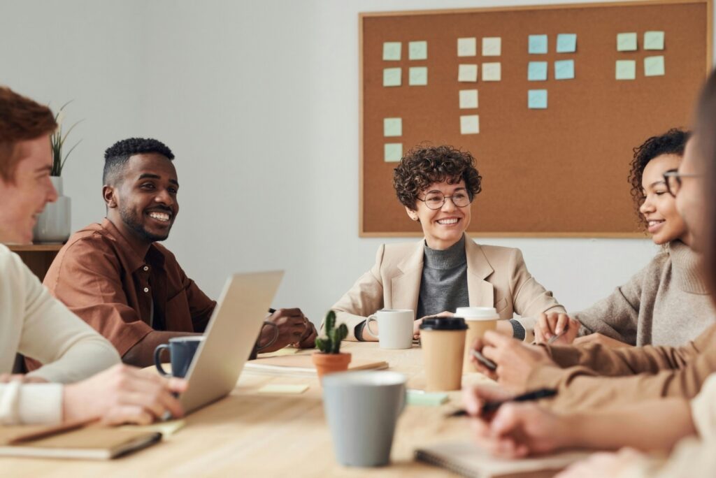 A group of employees are at a table during a meeting with HR discussing health insurance plans without deductible