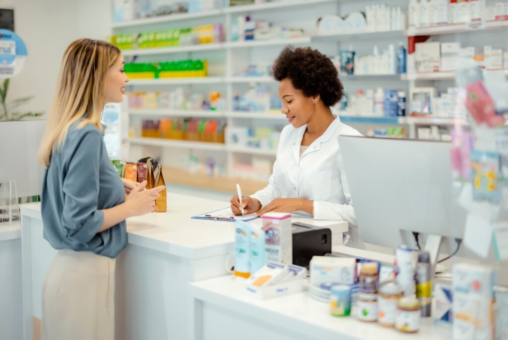 A young woman is being helped by a doctor at the pharmacy counter